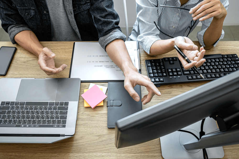 Image of two people working together